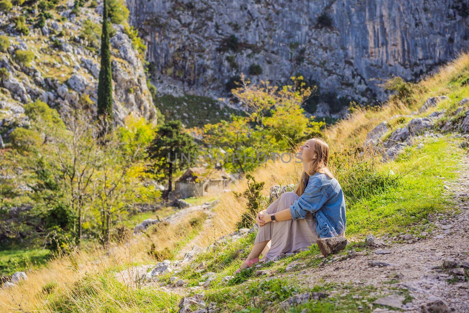 Woman tourist enjoys the view of Kotor. Montenegro. Bay of Kotor, Gulf of Kotor, Boka Kotorska and walled old city. Travel to Montenegro conceptFortifications of Kotor is on UNESCO World Heritage List since 1979.