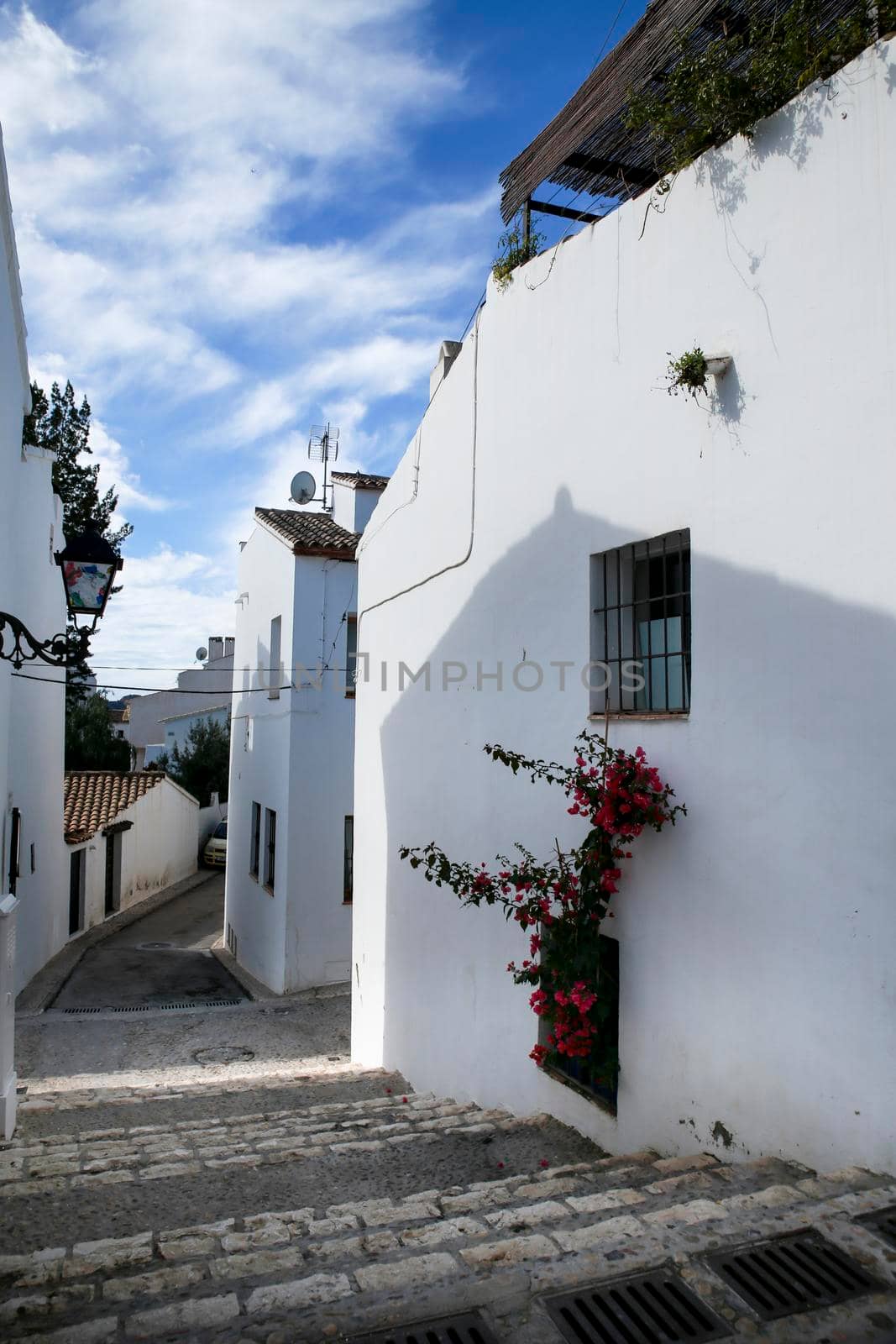 Beautiful whitewashed facades with colorful bougainvillea plant in Altea village, Alicante, Spain