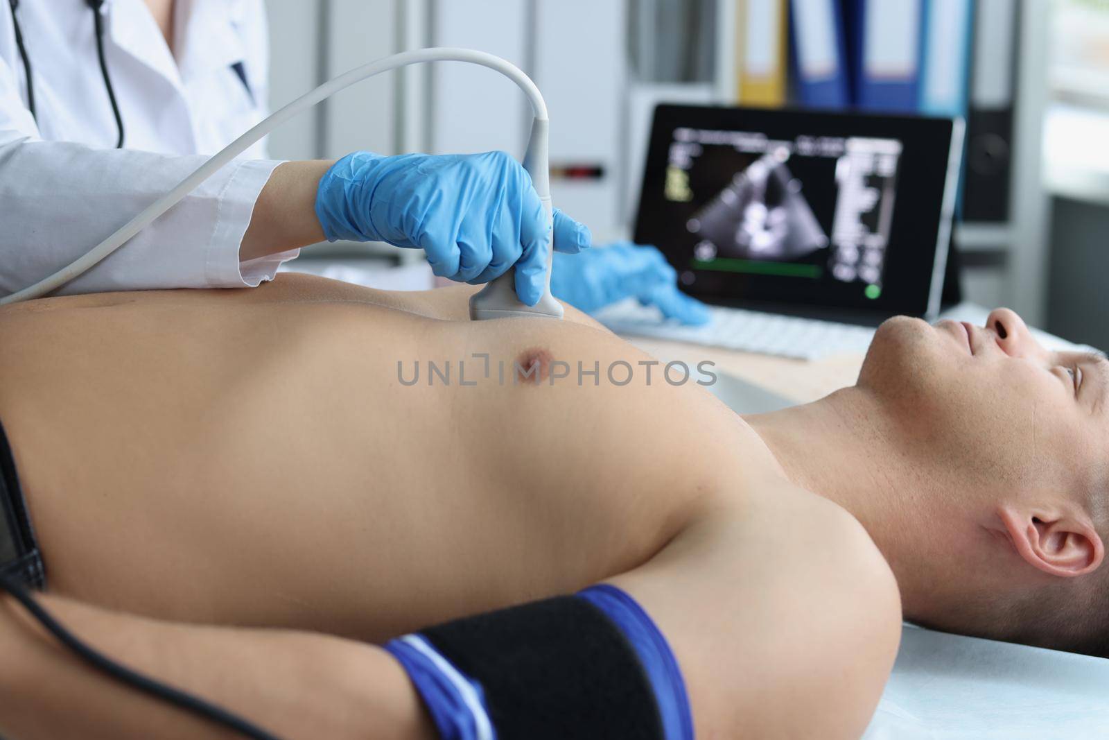 Doctor doing ultrasound of rib cage, cardiologist examining a patients heart by kuprevich