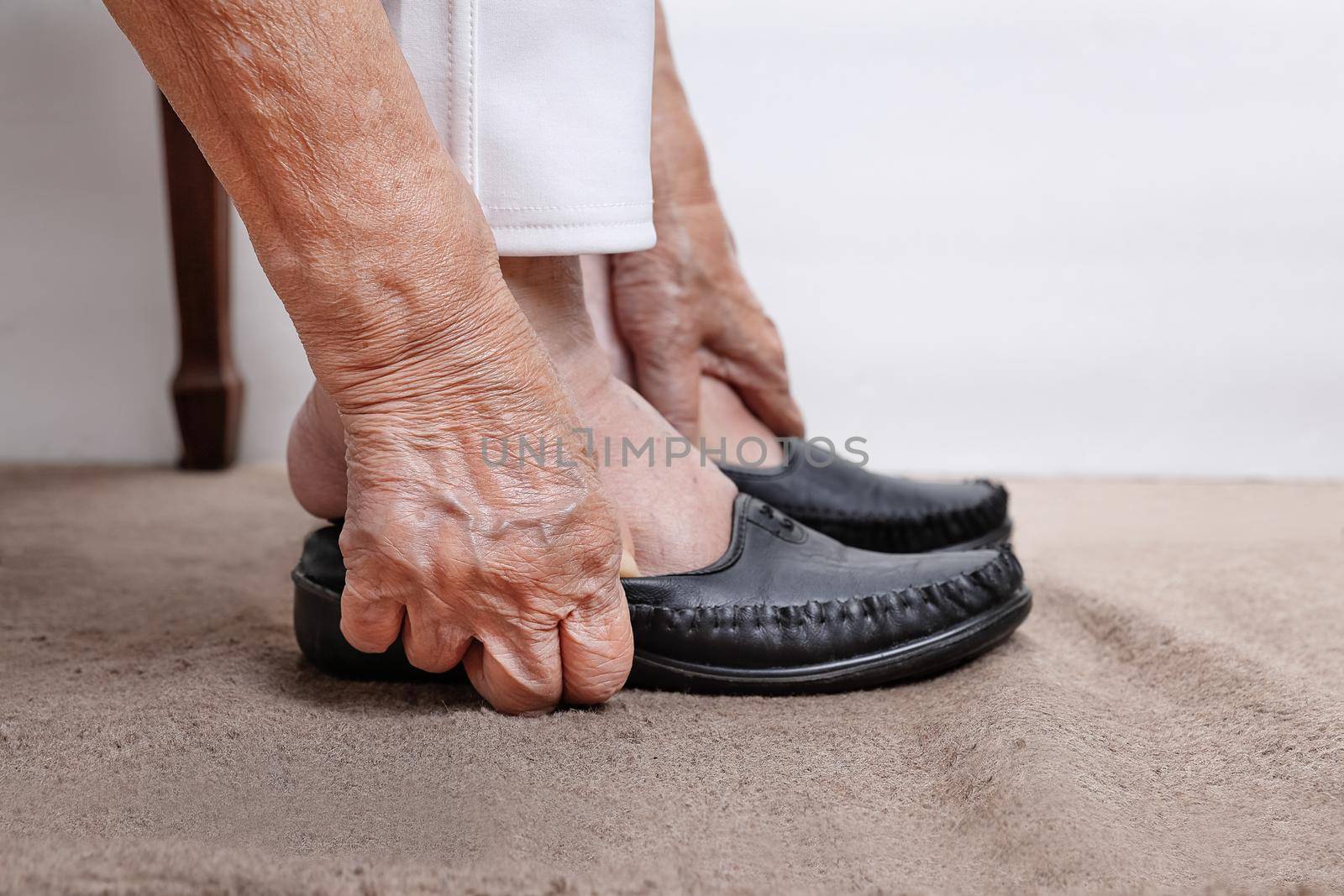 Elderly woman putting on shoes by toa55