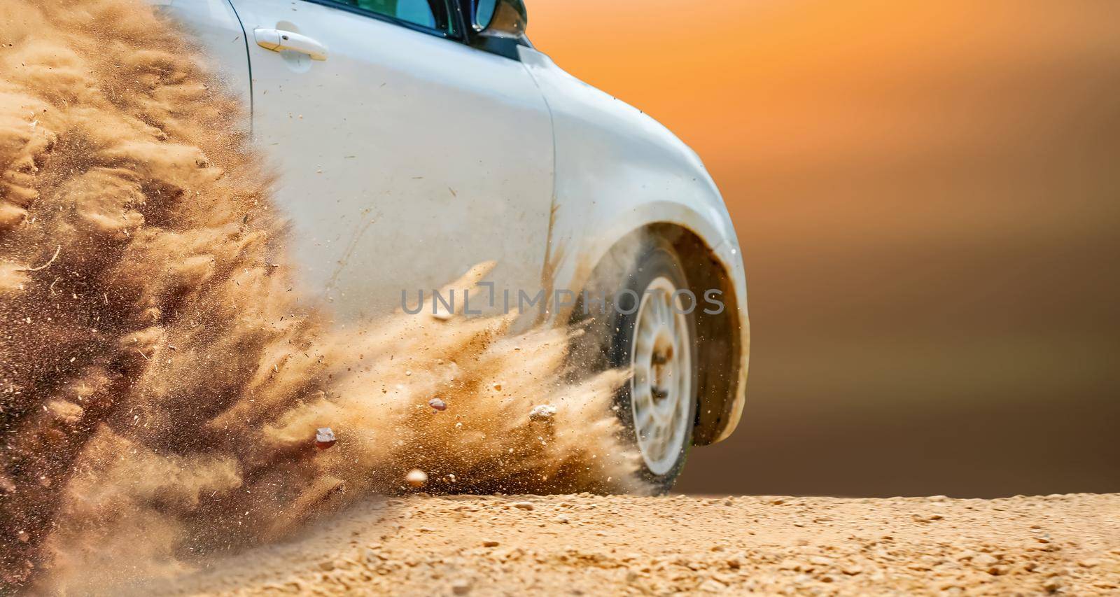 Rally race car drifting on dirt track.