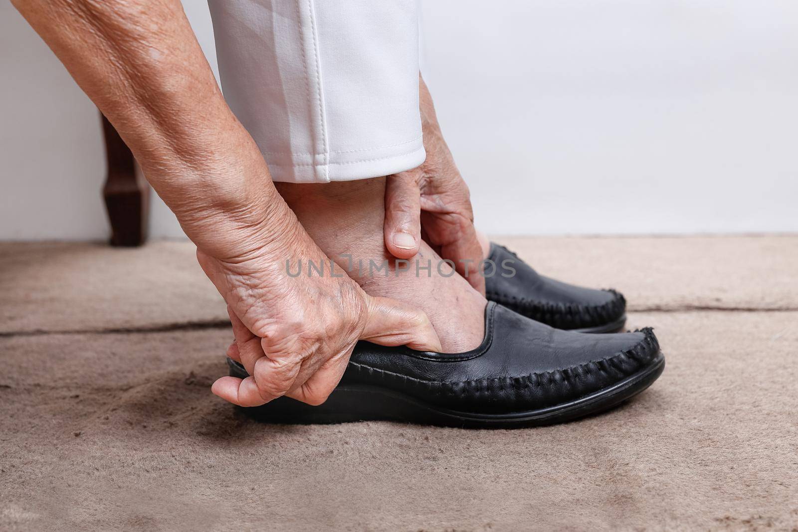 Elderly woman putting on shoes