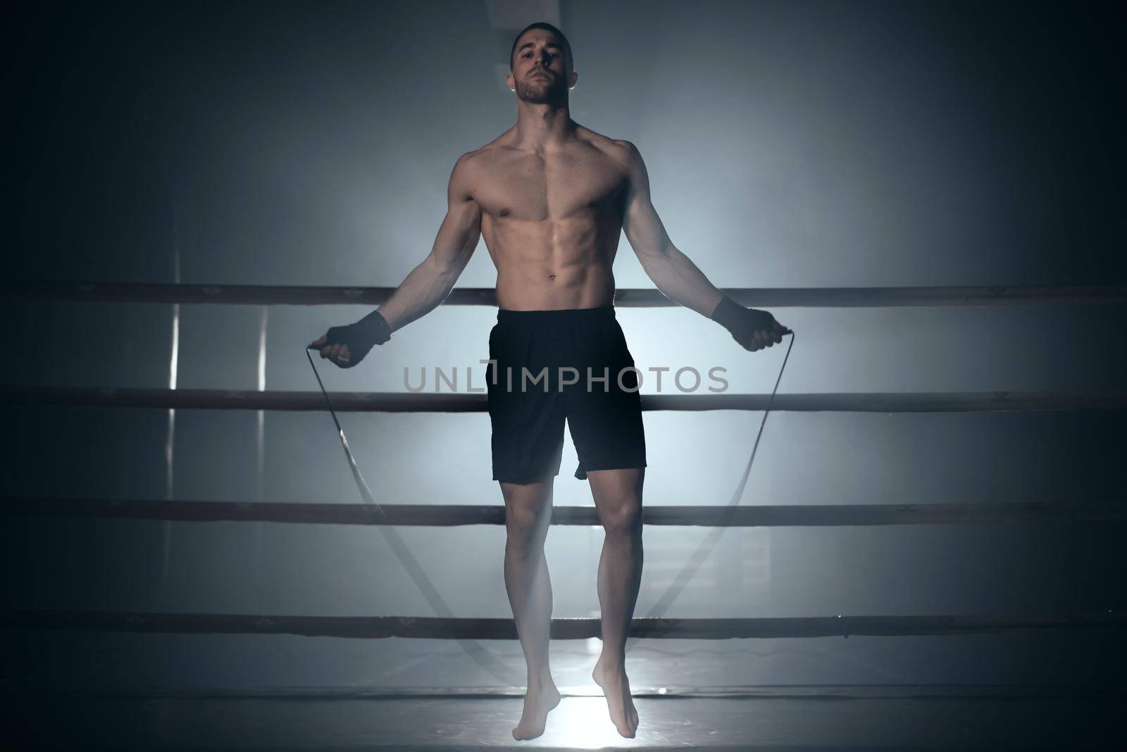 Boxer jumping rope in boxing ring. by HERRAEZ