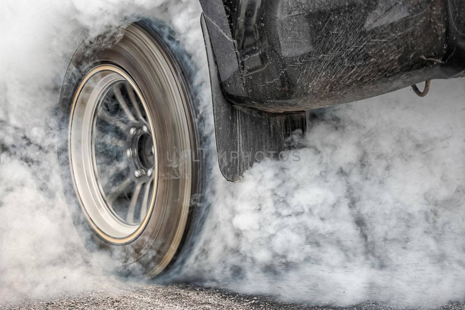 Drag racing car burns rubber off its tires in preparation for the race by toa55