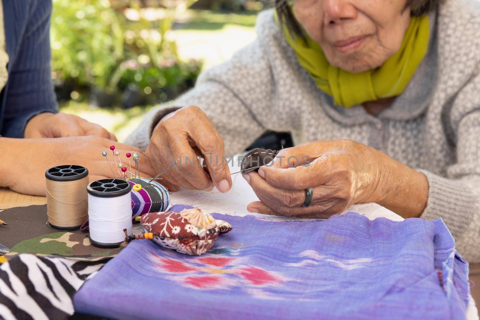 Elderly woman and daughter in the needle crafts occupational therapy for Alzheimer’s or dementia