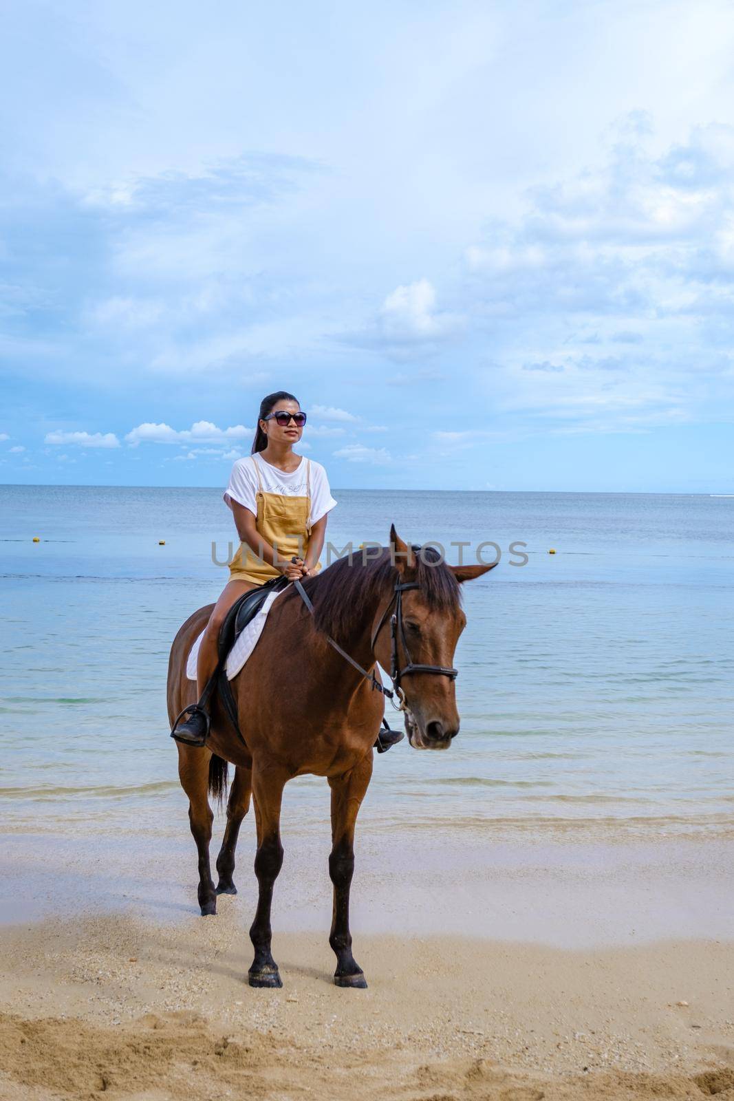 horse riding on the beach, woman on a horse on the beach during a luxury vacation in Mauritius.