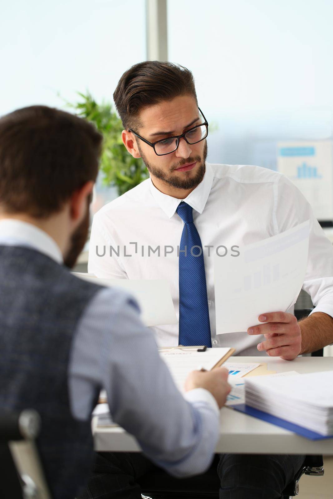 Portrait of coworkers men working at financial papers, solve and discuss problems. Businessmen analysing project profitability. Investment market concept
