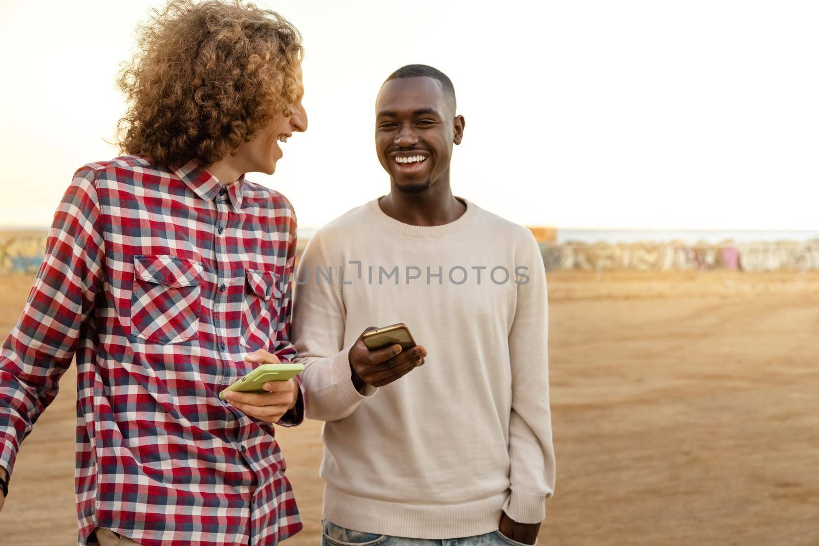 Multiracial male friends enjoy some time together laughing outdoors. Copy space. Friendship concept.