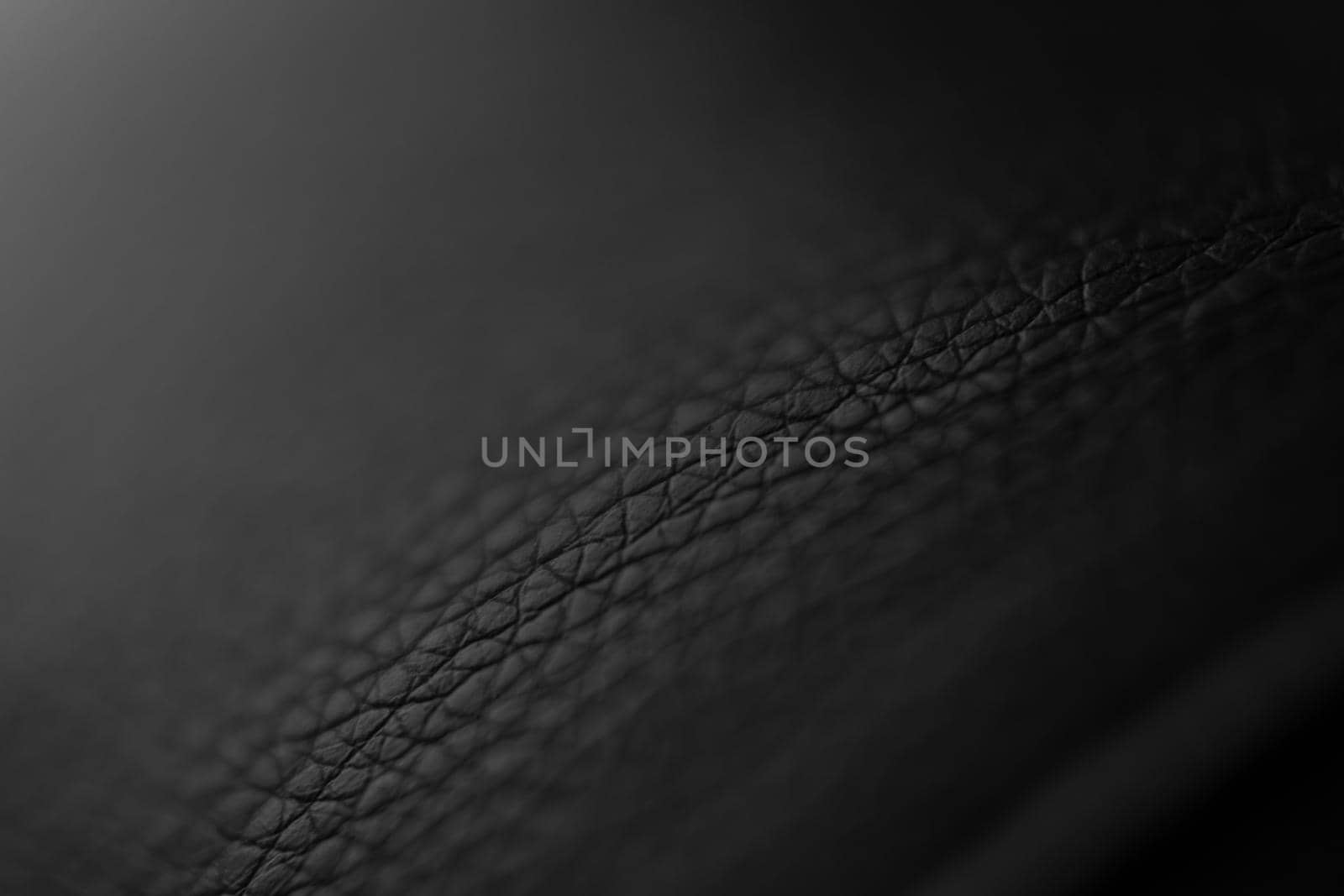 The structure of dermantine fabric close-up. Selective focus. Abstract dark background with gradient. Backdrop