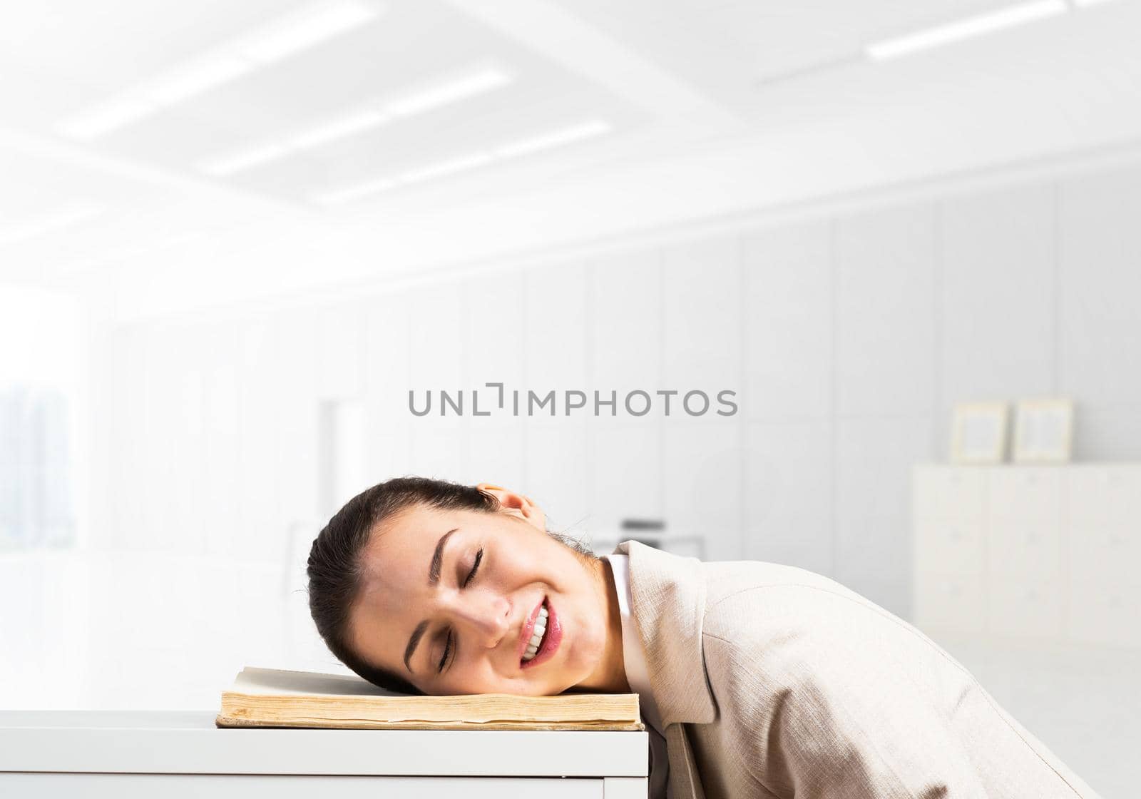 Exhausted business woman sleeping on desk with open notebook. Tired corporate employee relaxing in office. Young female worker in white suit overworking. Accounting and paperwork deadline concept.