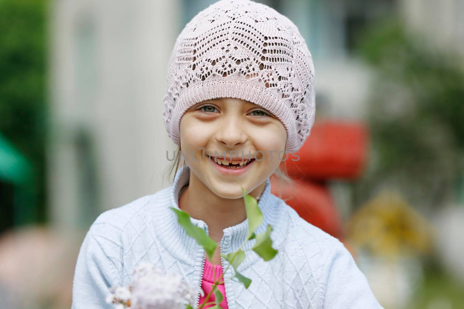 Belarus, the city of Gomil, May 16, 2016. Kindergarten. A little girl in a knitted hat looks at the camera and smiles.