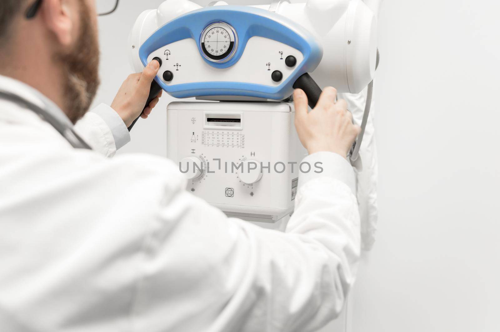 Doctor operating X-ray machine in radiology department. High quality photography.