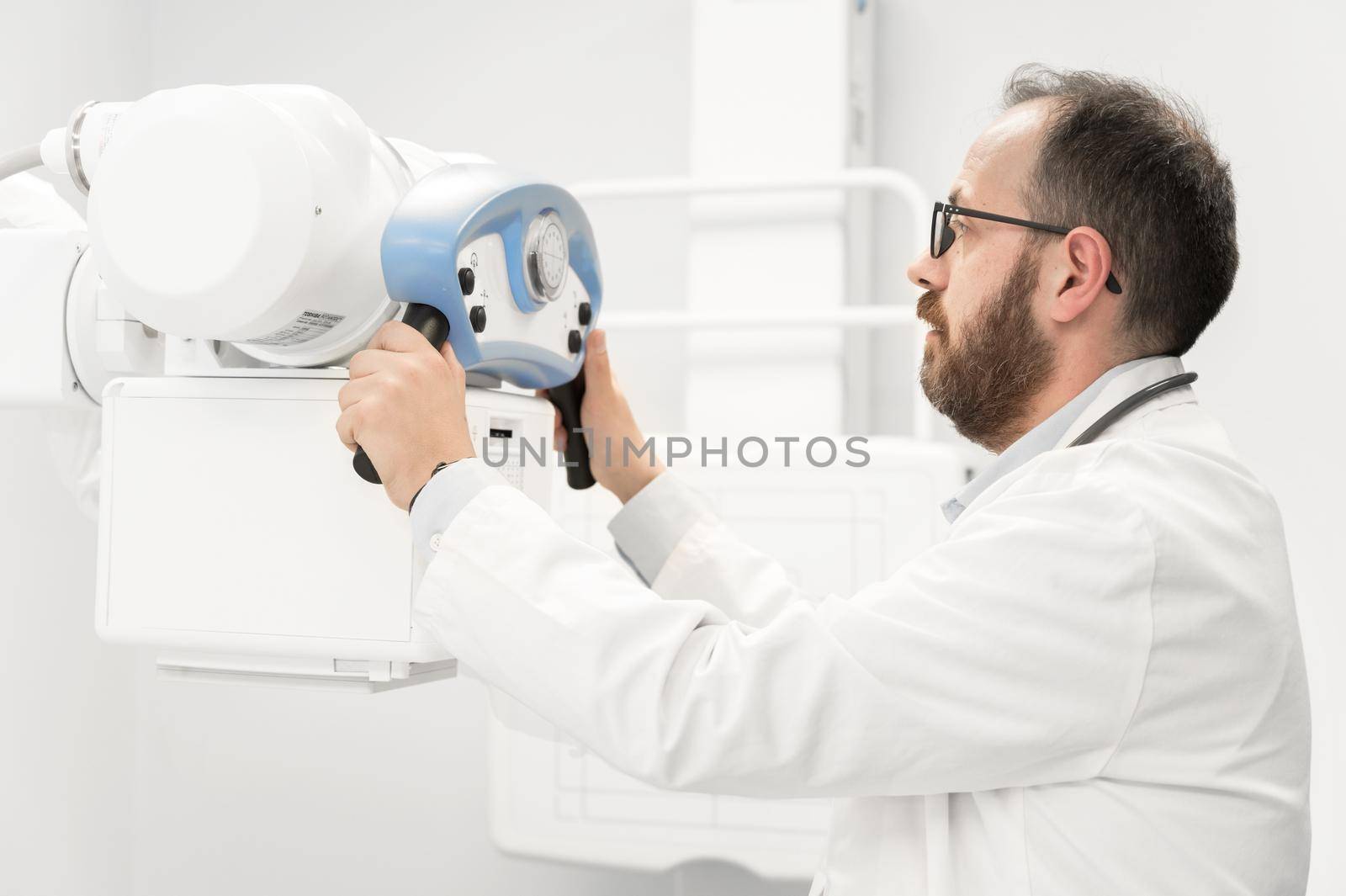 Doctor operating X-ray machine in radiology department. High quality photography.