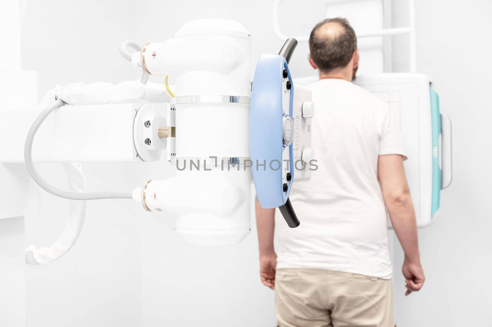 Man in x-ray room having medical scan examination in a modern hospital. High quality photo