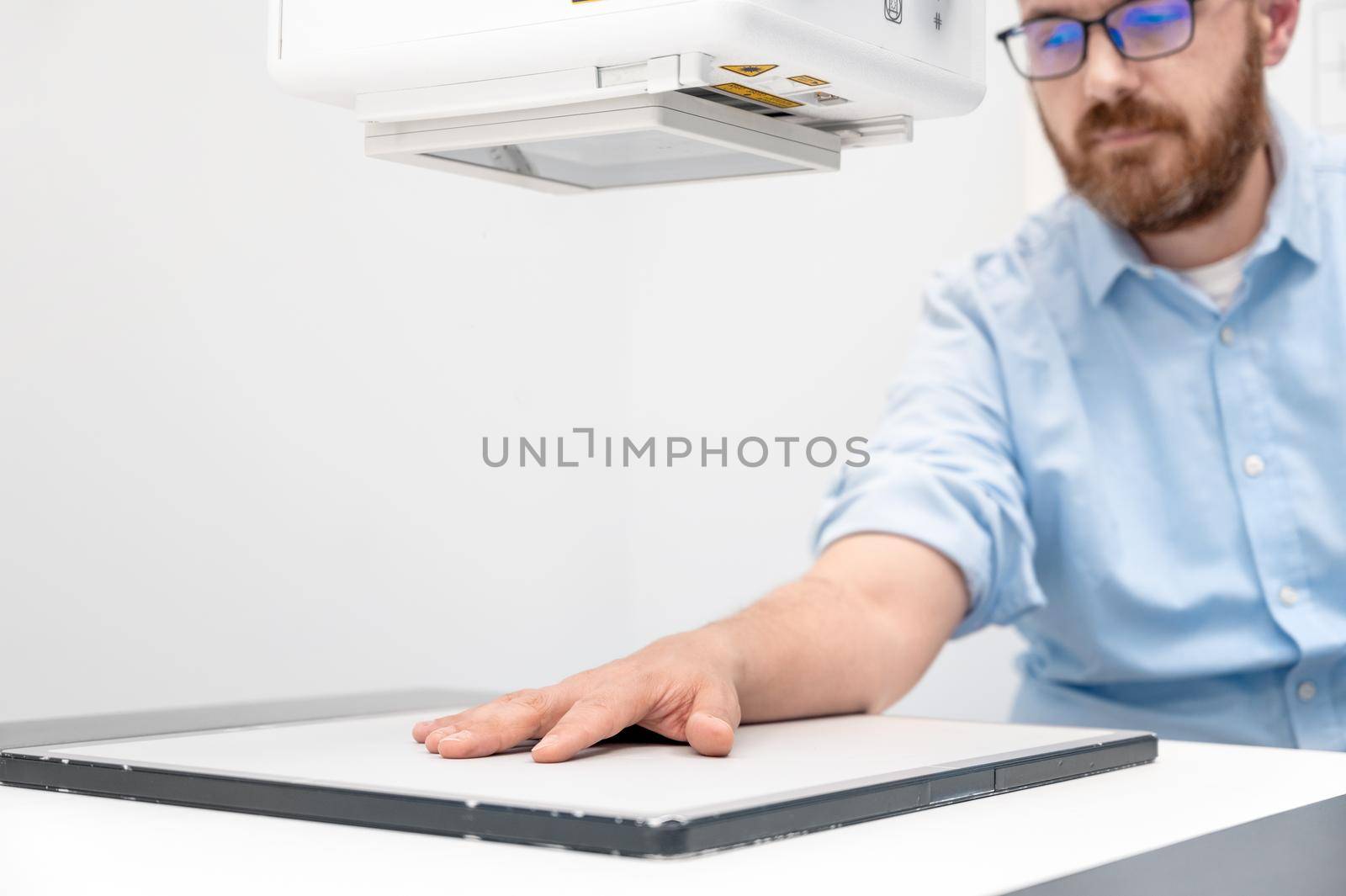 Man in x-ray room having medical scan examination in a modern hospital. by HERRAEZ