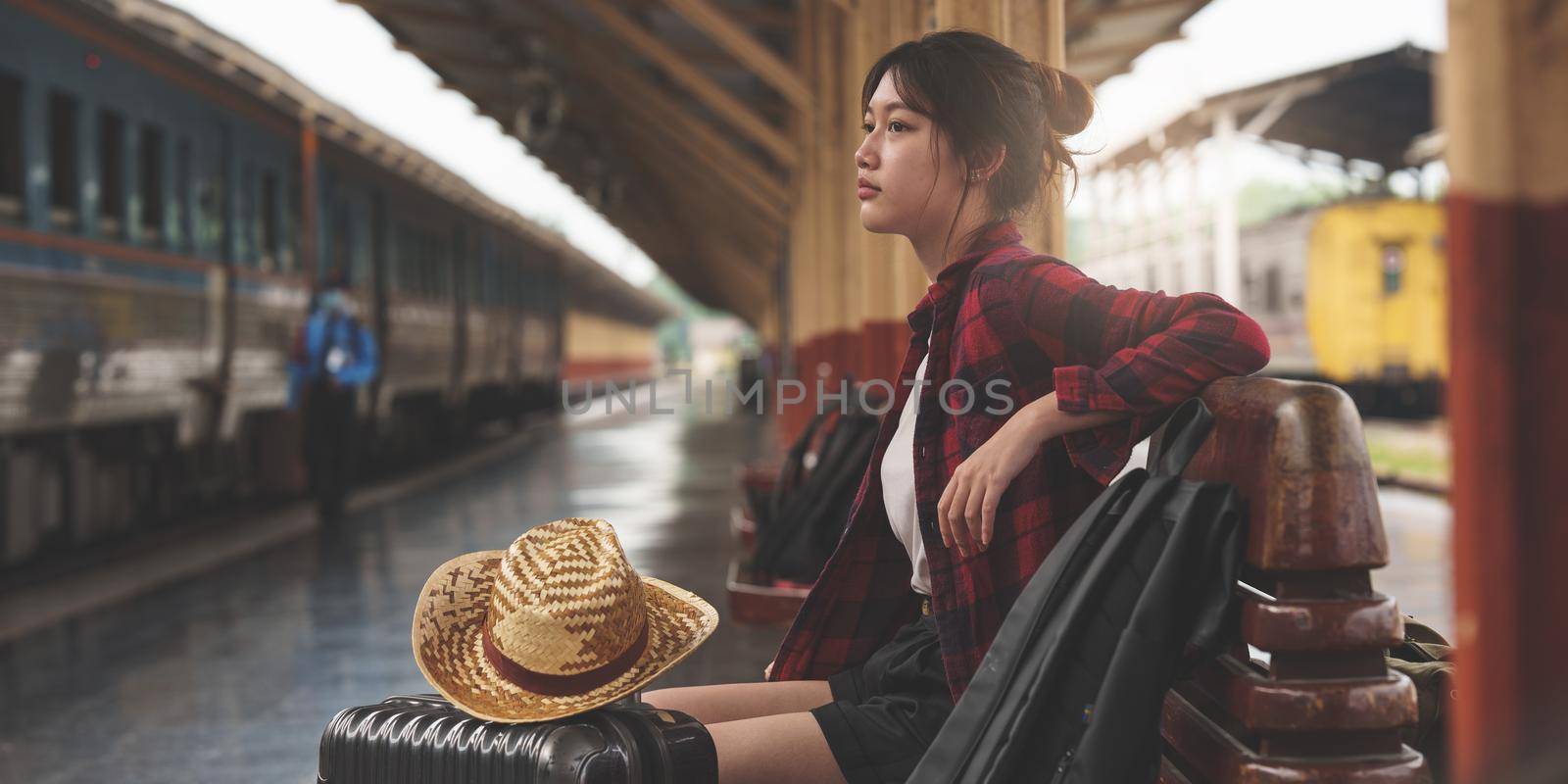 Young traveler woman looking for friend planning trip at train station. Summer and travel lifestyle concept