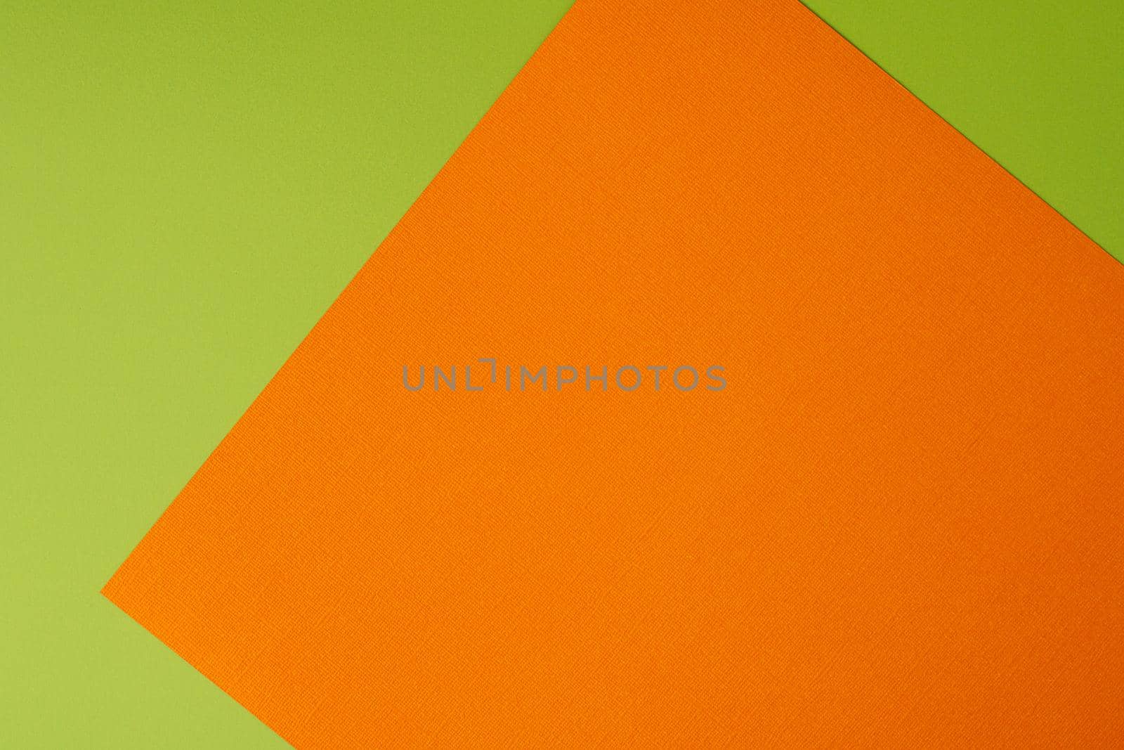 Orange and green colored background of overlapped cardboard layered geometric shaped sheets. Abstract design concept. Surface elements. Shredded texture, craft backdrop