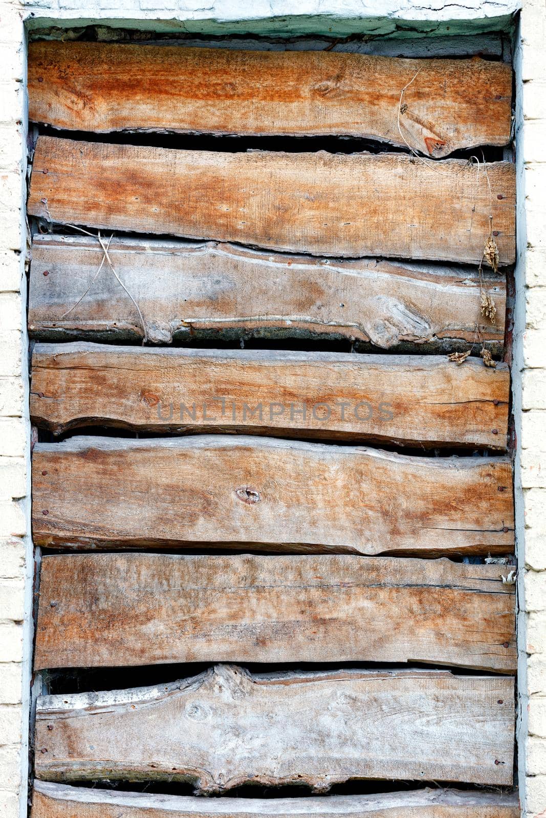 Close-up of a boarded up window opening, weathered board texture, image with copy space.