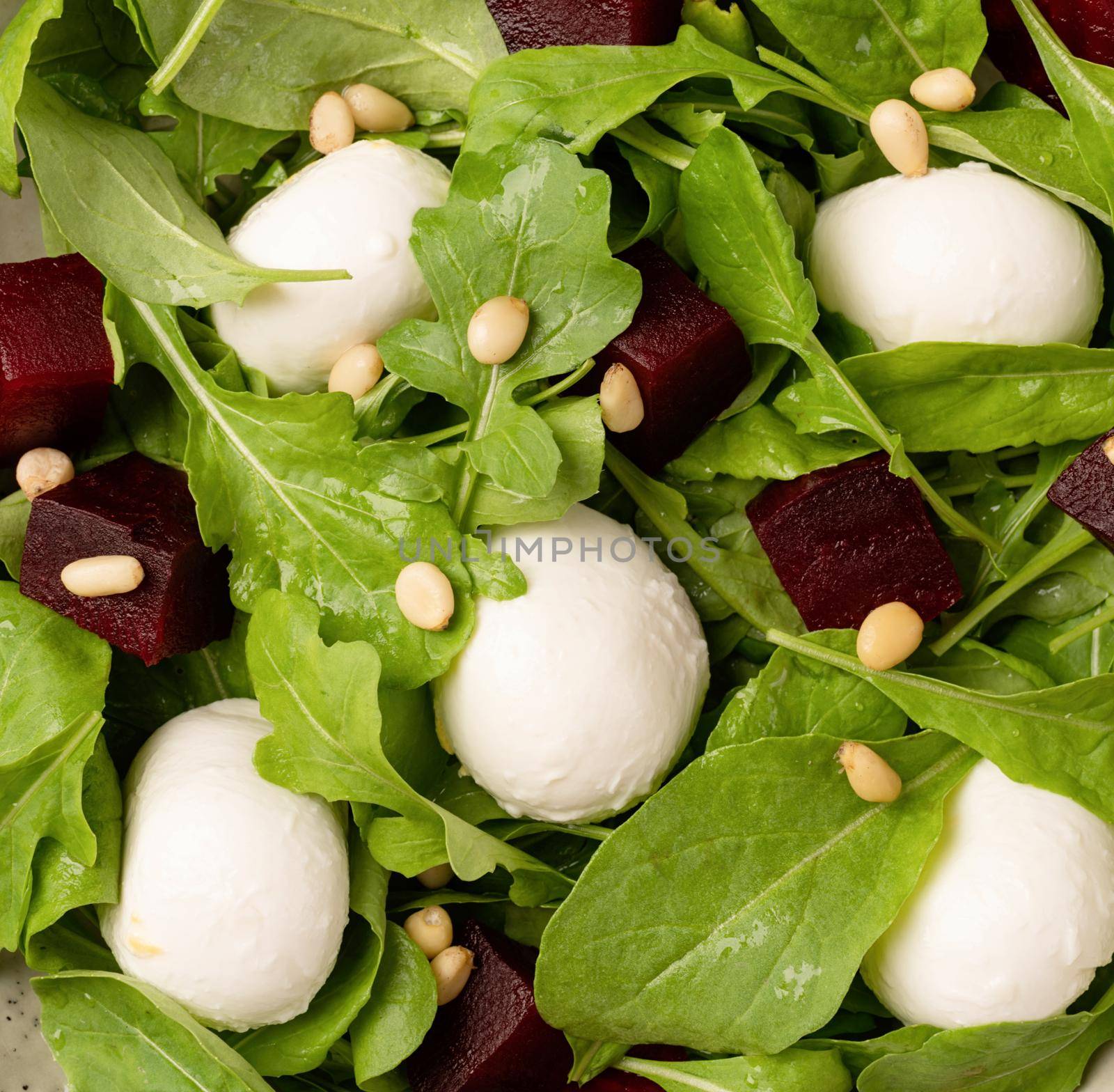 Healthy eating. Beetroot, mozzarella and arugula salad with pine nuts top view