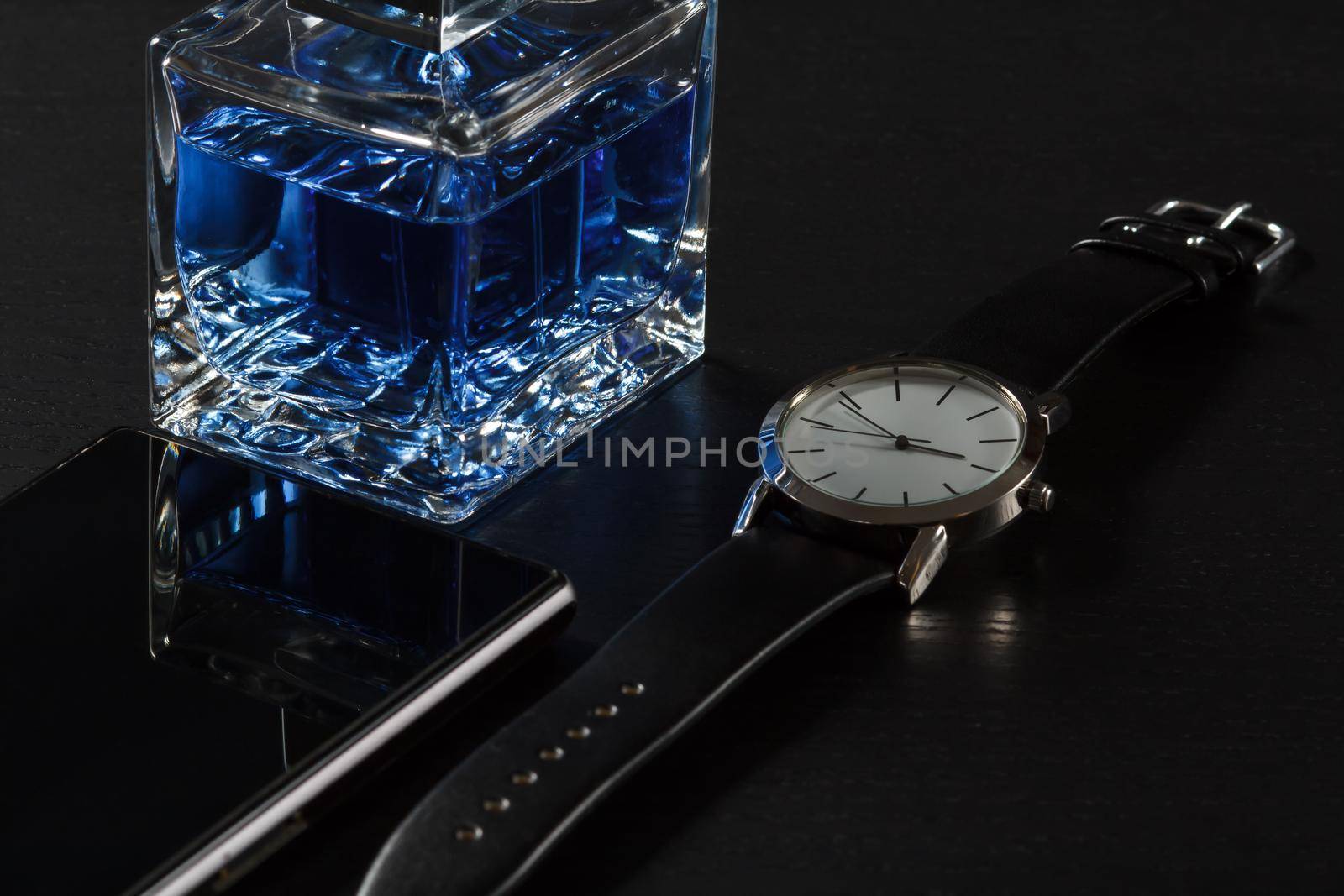 Man perfume, watch with a leather strap, sell phone, on a black background