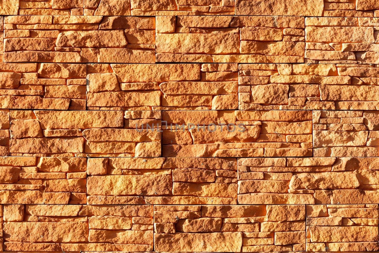 Orange stone background and texture of weathered tiles in harsh sunlight. by Sergii