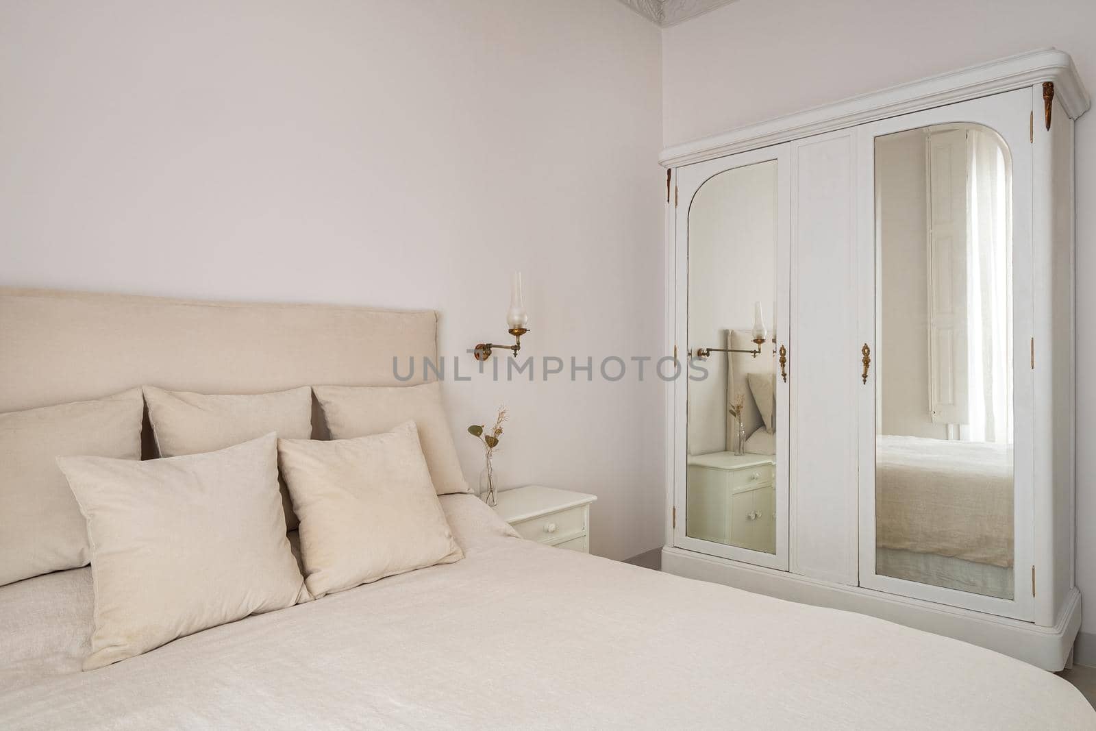 Bedroom interior with big cozy bed and vintage wardrobe with mirrors. Retro and classic style