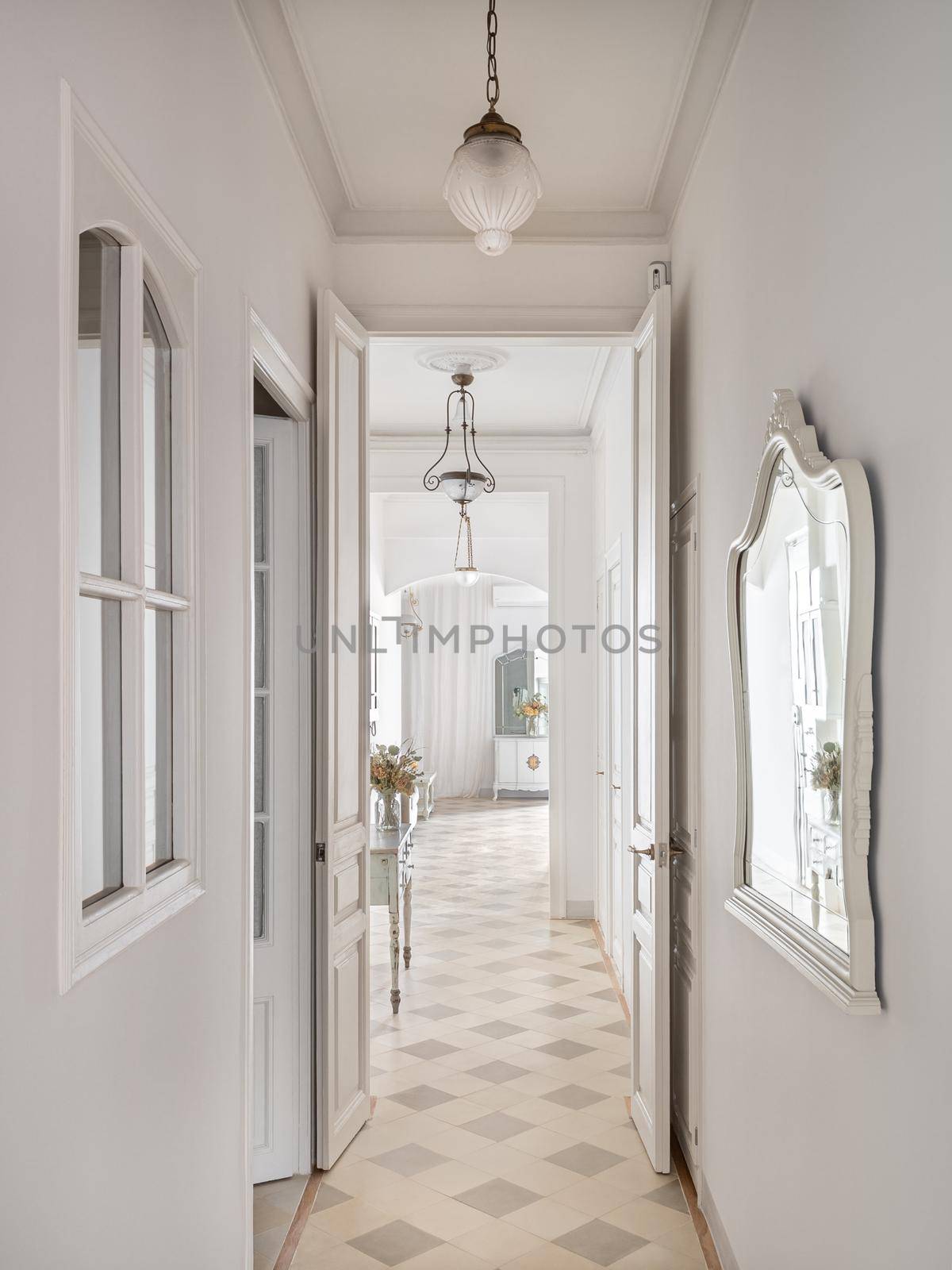Hallway with vintage chandeliers overlooking a long corridor with many doors to the rooms. by apavlin