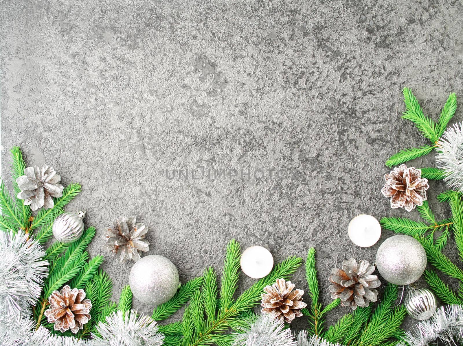 Christmas and Happy New Year gray stone background. Top view, copy space, military stile. Fir branches, a silver concrete