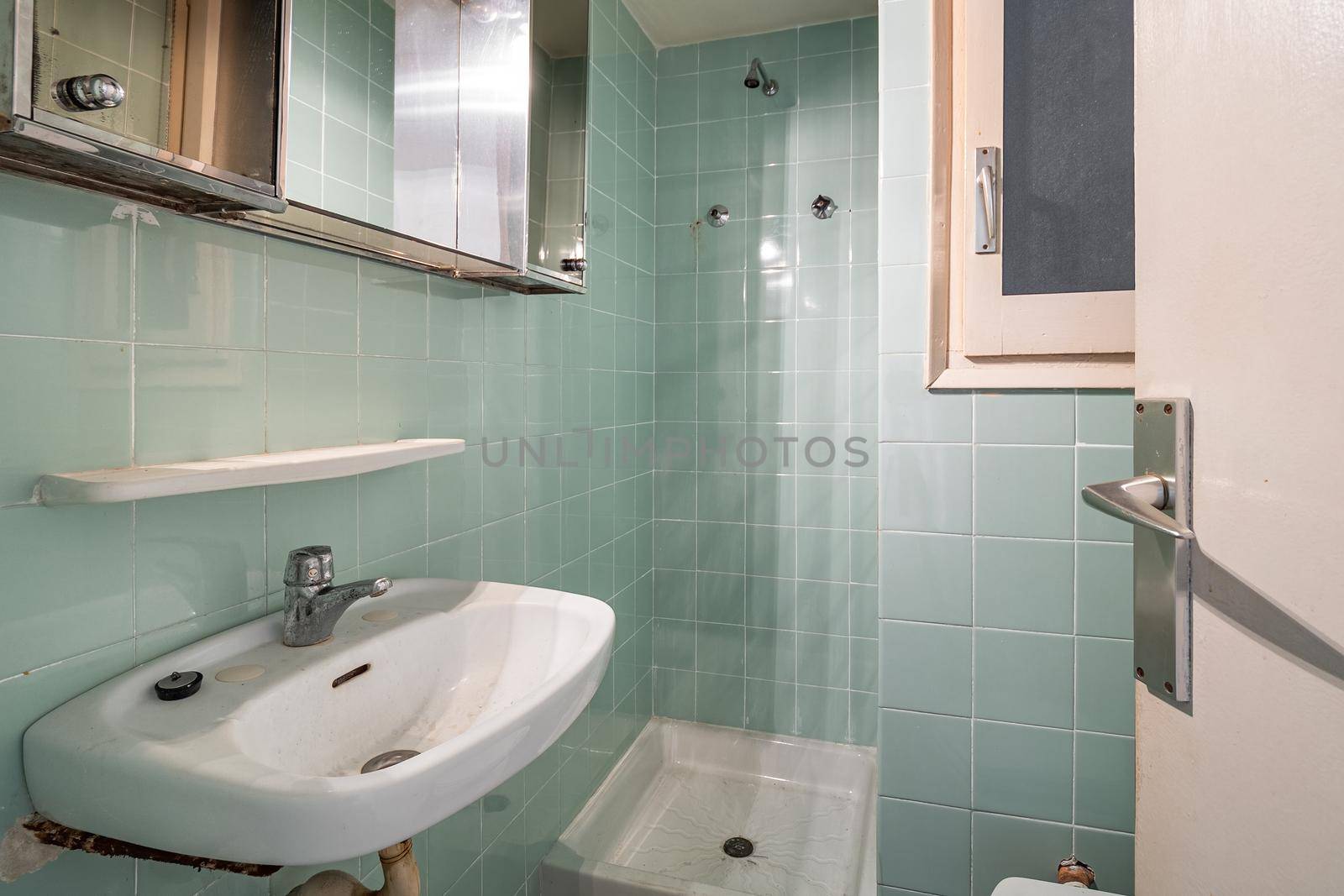 Empty, old and dirty bathroom with blue tiles in an old house of Barcelona by apavlin