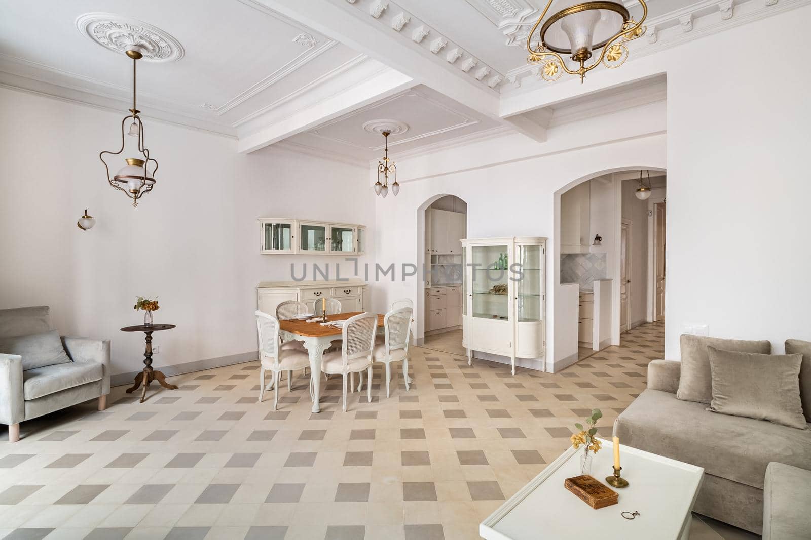 Classic room with dining table, served for two persons, tile floor, light walls, balconies and vintage elements of decoration. Beautiful bright interior.