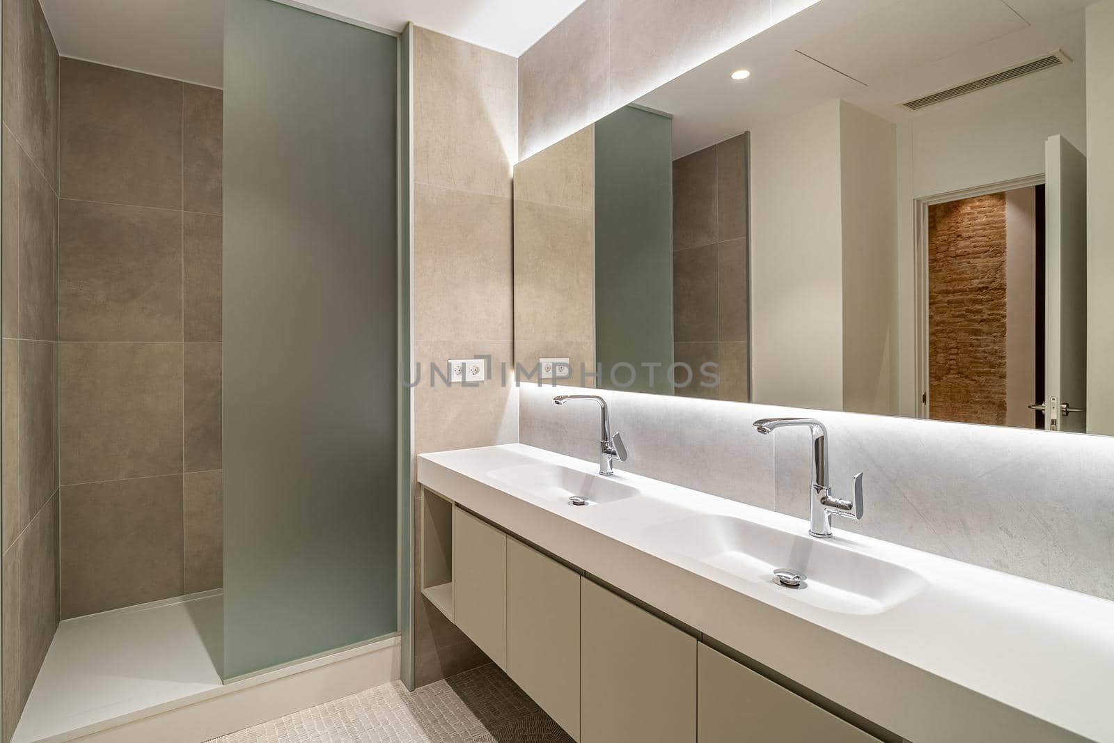 Modern tiled bathroom with a shower area, two sinks and a big wall mirror by apavlin