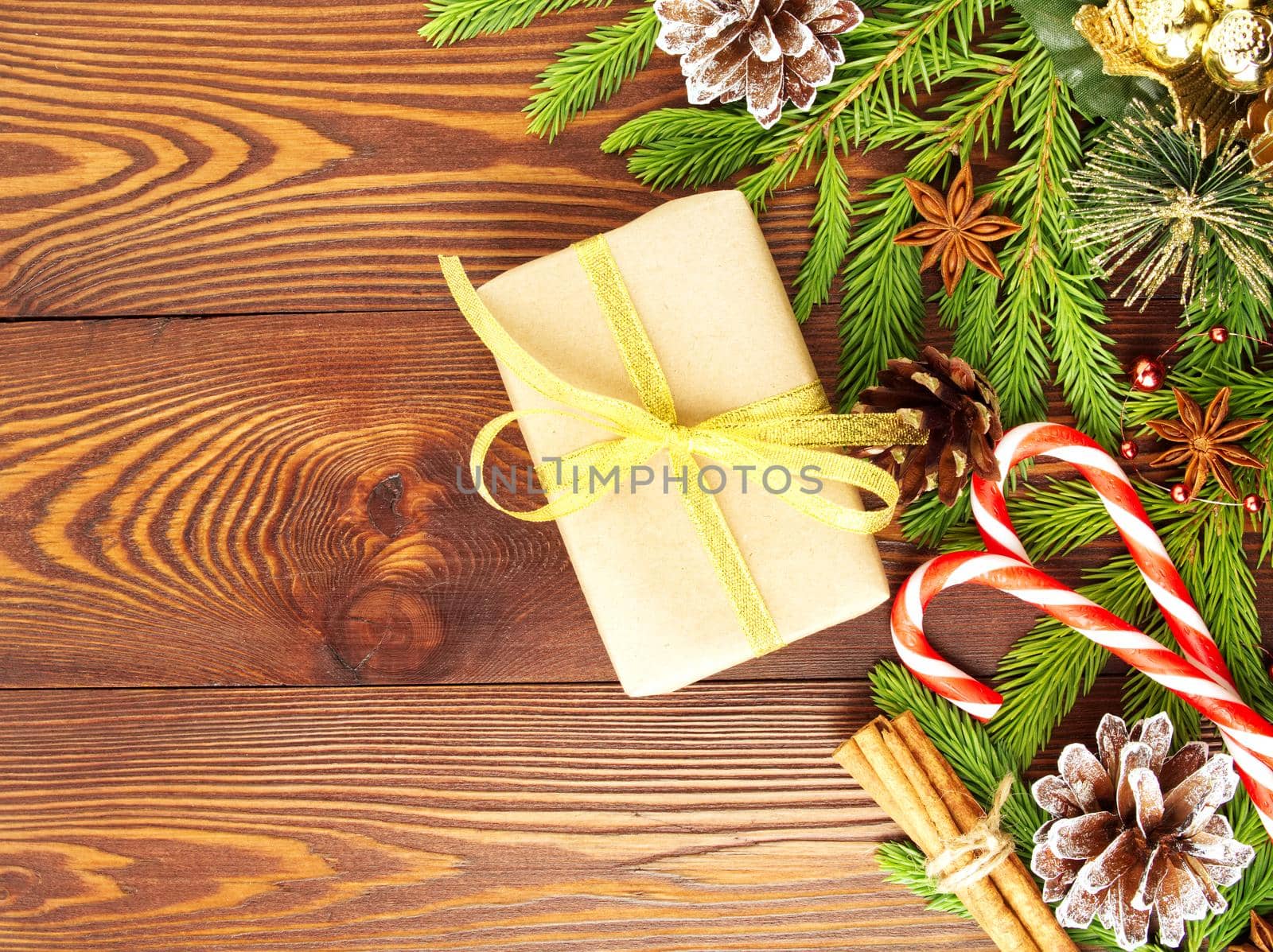 Christmas and Happy New Year dark brown background. Gift Christmas box, fir branches by NataBene