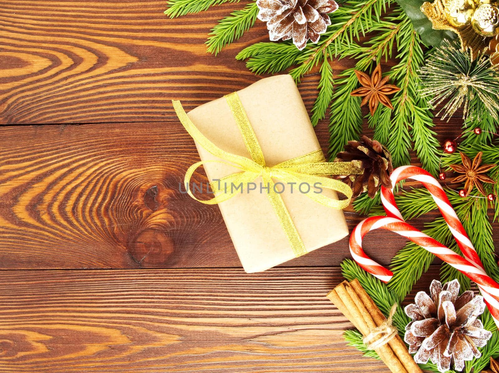 Christmas and Happy New Year dark brown background. Gift Christmas box, fir branches, a wooden table, top view, copy space