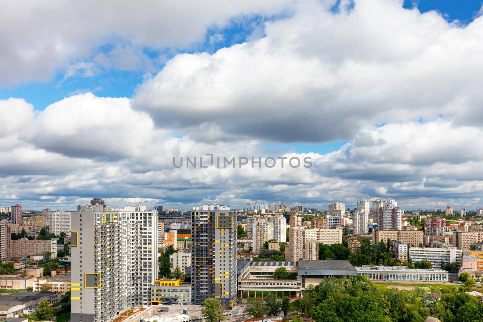 An urban landscape with high and low architecture under a beautiful dramatic sky with dense thick clouds.