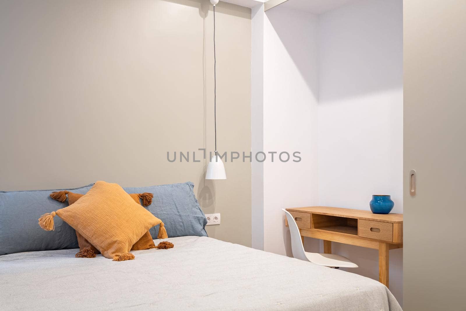 Interior of new bedroom with small working table and window. Bright room with pleasant and calm colors