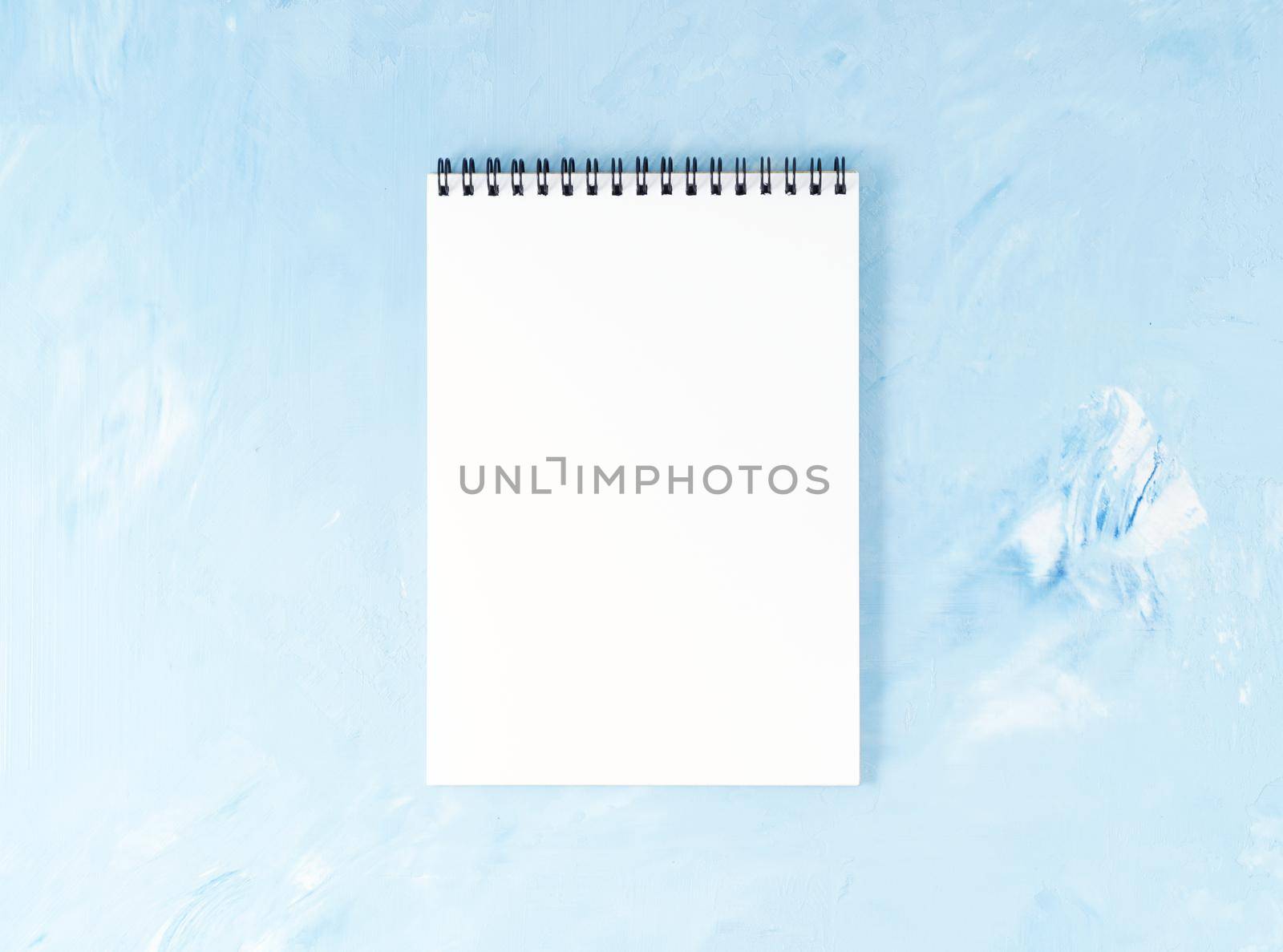 Top view of modern bright blue office desktop with notepad. Mock up, empty space by NataBene