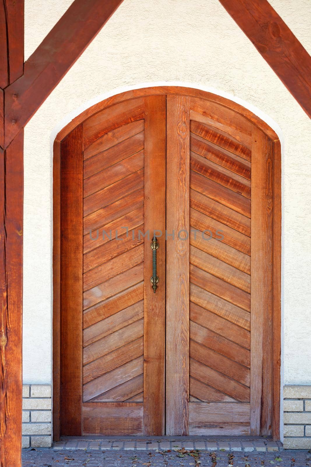 Front entrance wooden doors of a Ukrainian village hut with a massive copper handle. by Sergii