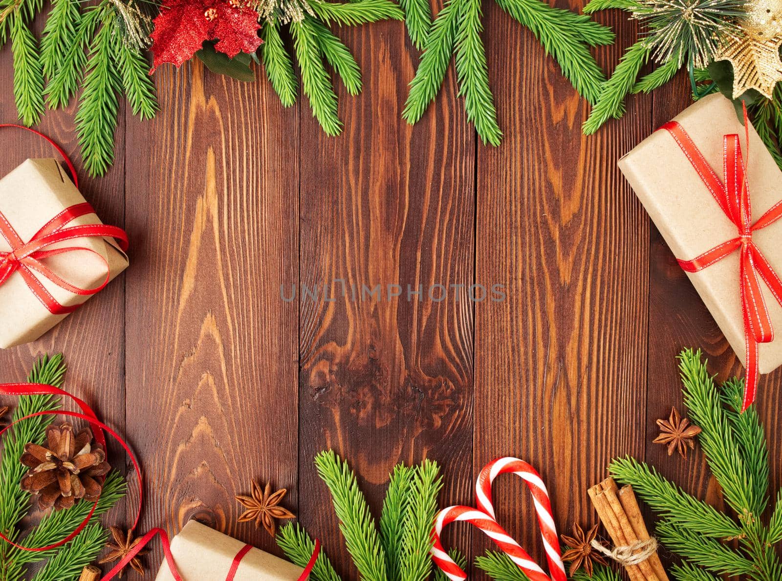 Christmas and Happy New Year dark brown background. Gift Christmas box, fir branches, a wooden table, top view, copy space