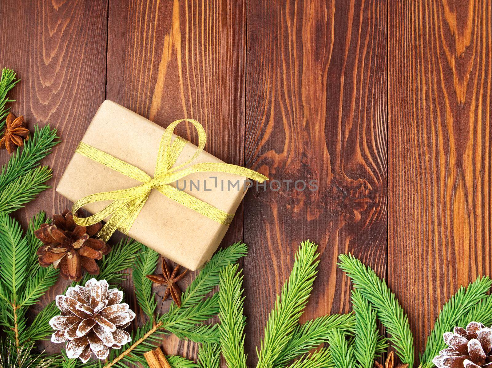 Christmas and Happy New Year dark brown background. Gift Christmas box, fir branches, wooden table, top view, copy space by NataBene