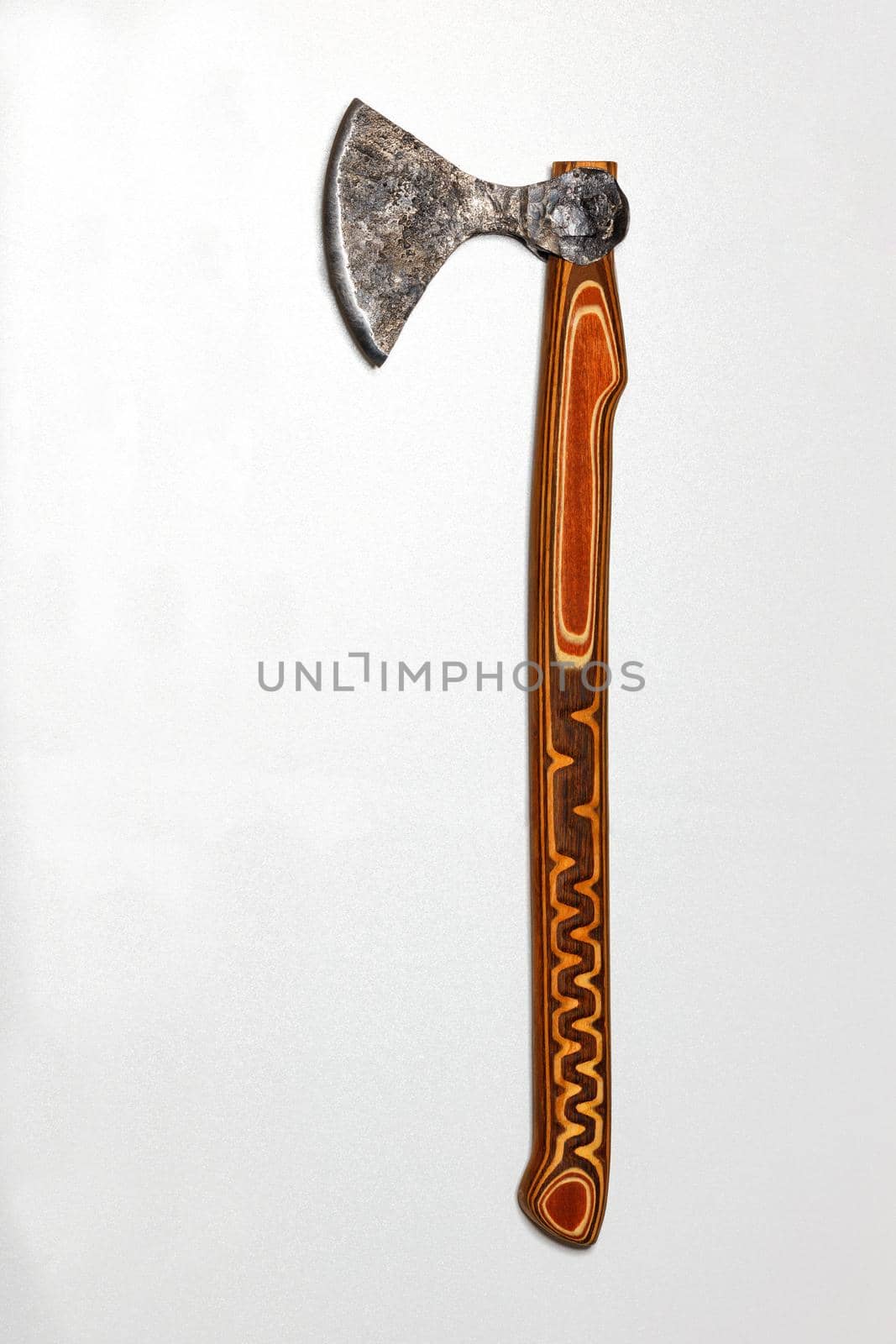 Battle ax of an antique Ukrainian warrior with a carved wooden handle on a gray silver background. by Sergii