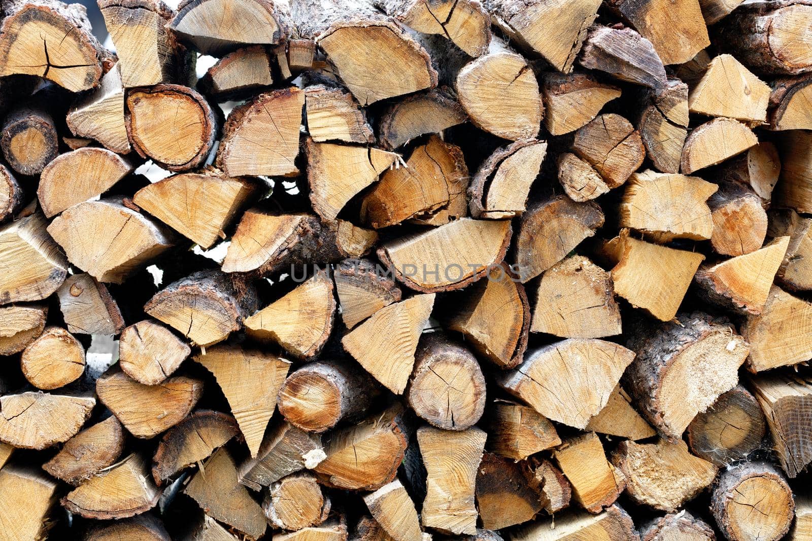 Coarsely chopped and neatly stacked firewood, prepared for the oven, natural oak grain.