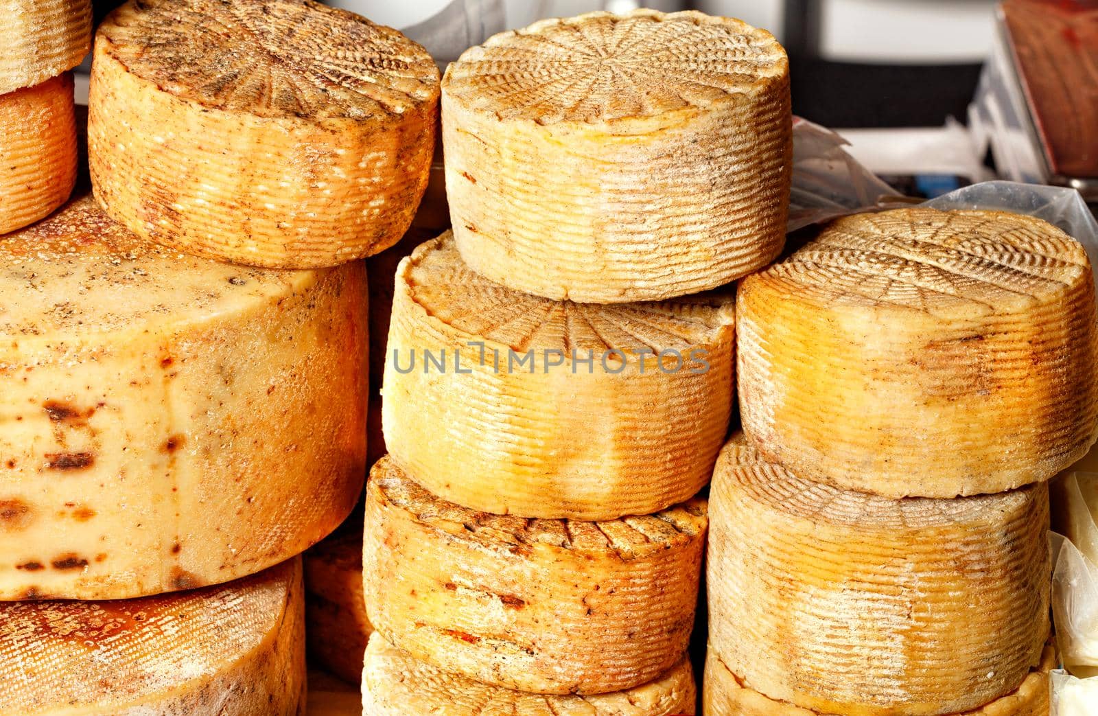 Heads of delicious homemade cheese on the market counter. by Sergii