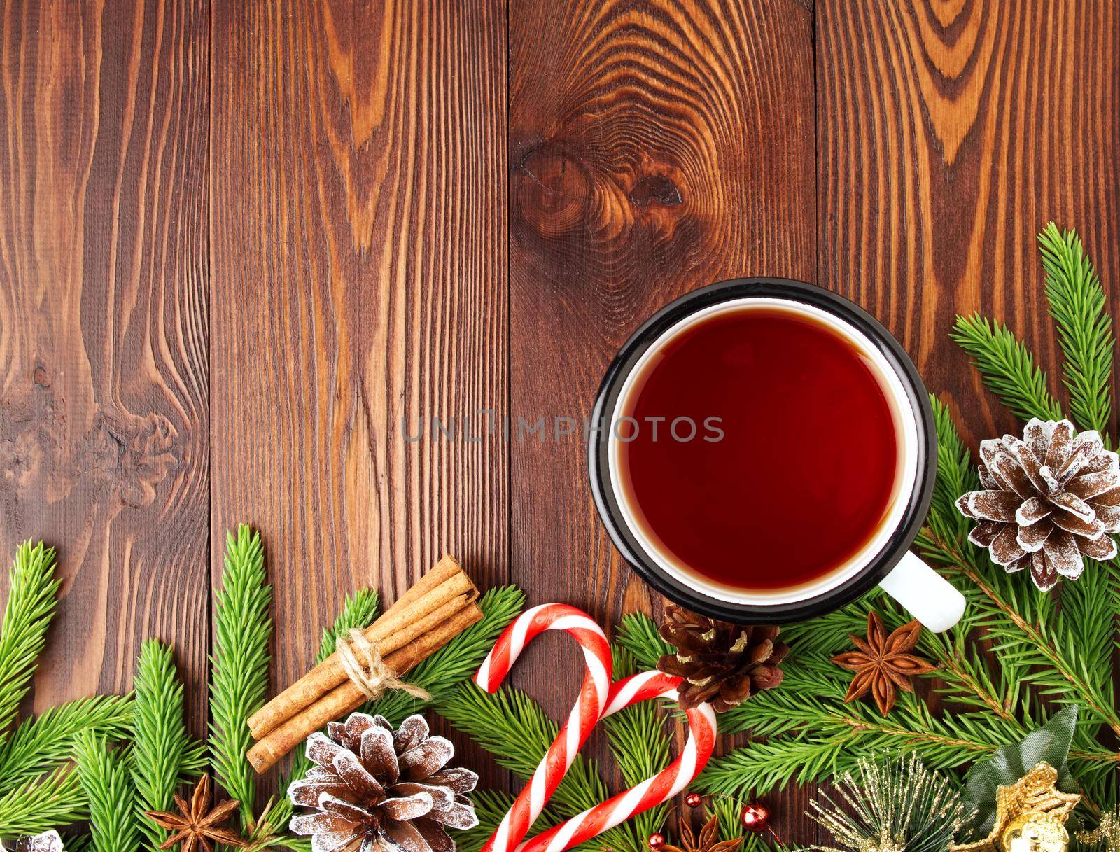 Christmas and Happy New Year background with tea. Top view, copy space. Fir branches, a brown dark wooden table