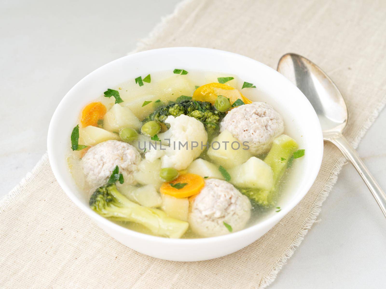 bowl of soup, a cup of broth and vegetables, meatballs made of turkey and chicken, top view by NataBene