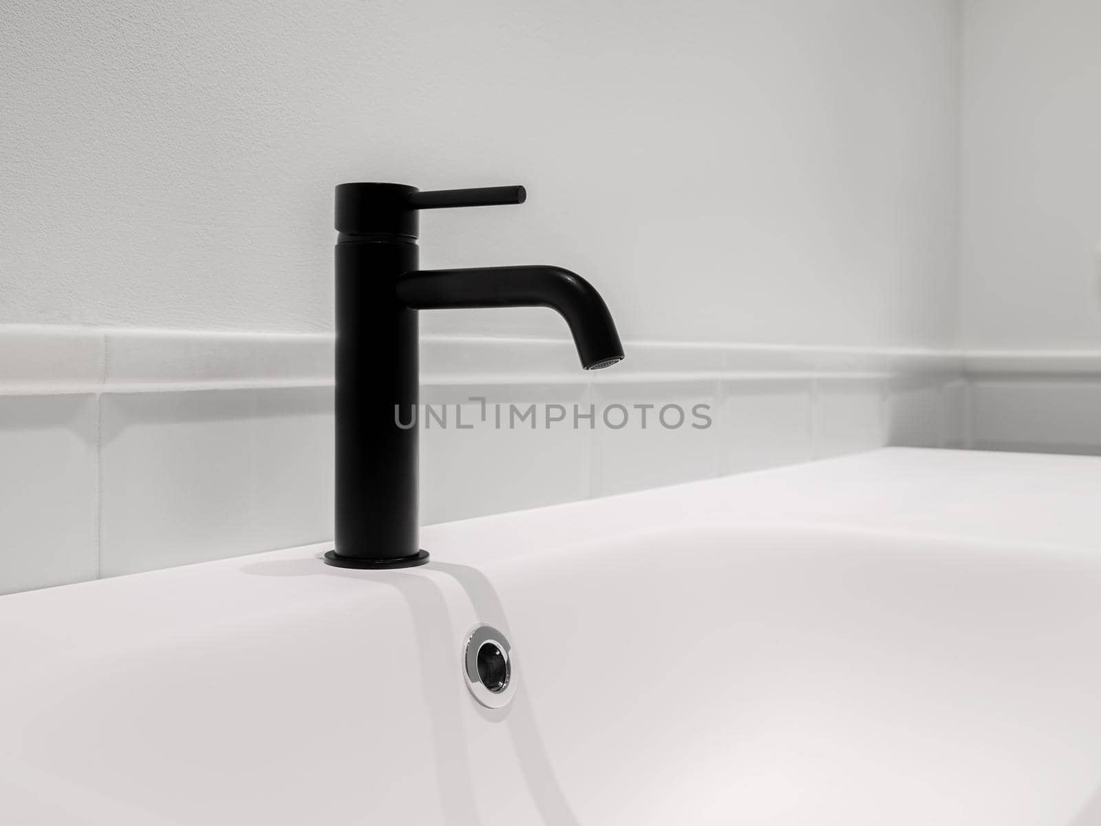 Small black faucet and sink in white clean bathroom. Copy space. by apavlin