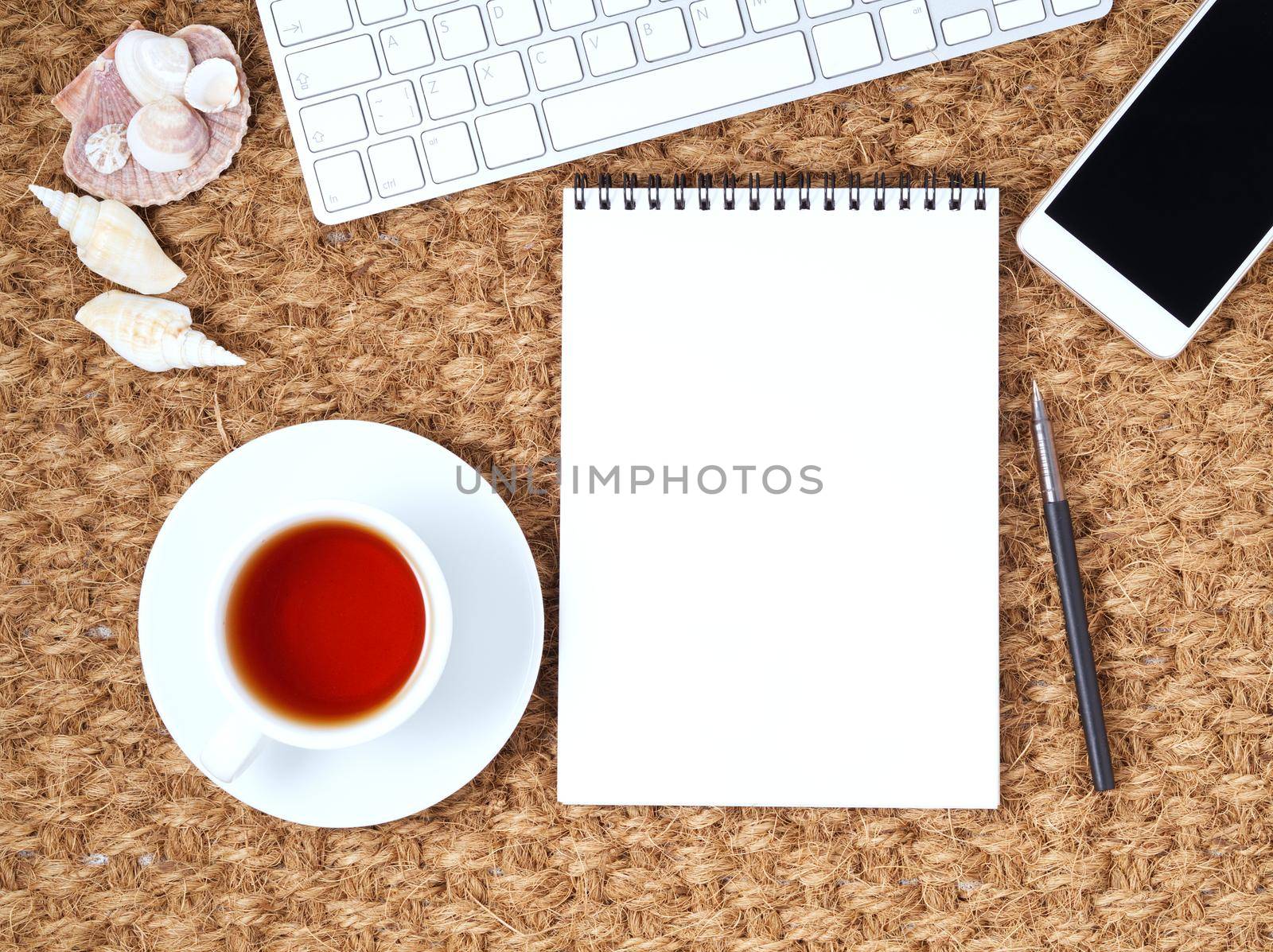 Workplace with laptop and blank notepad on mat. Top view. Flat lay. Freelance desktop, warm climate. by NataBene