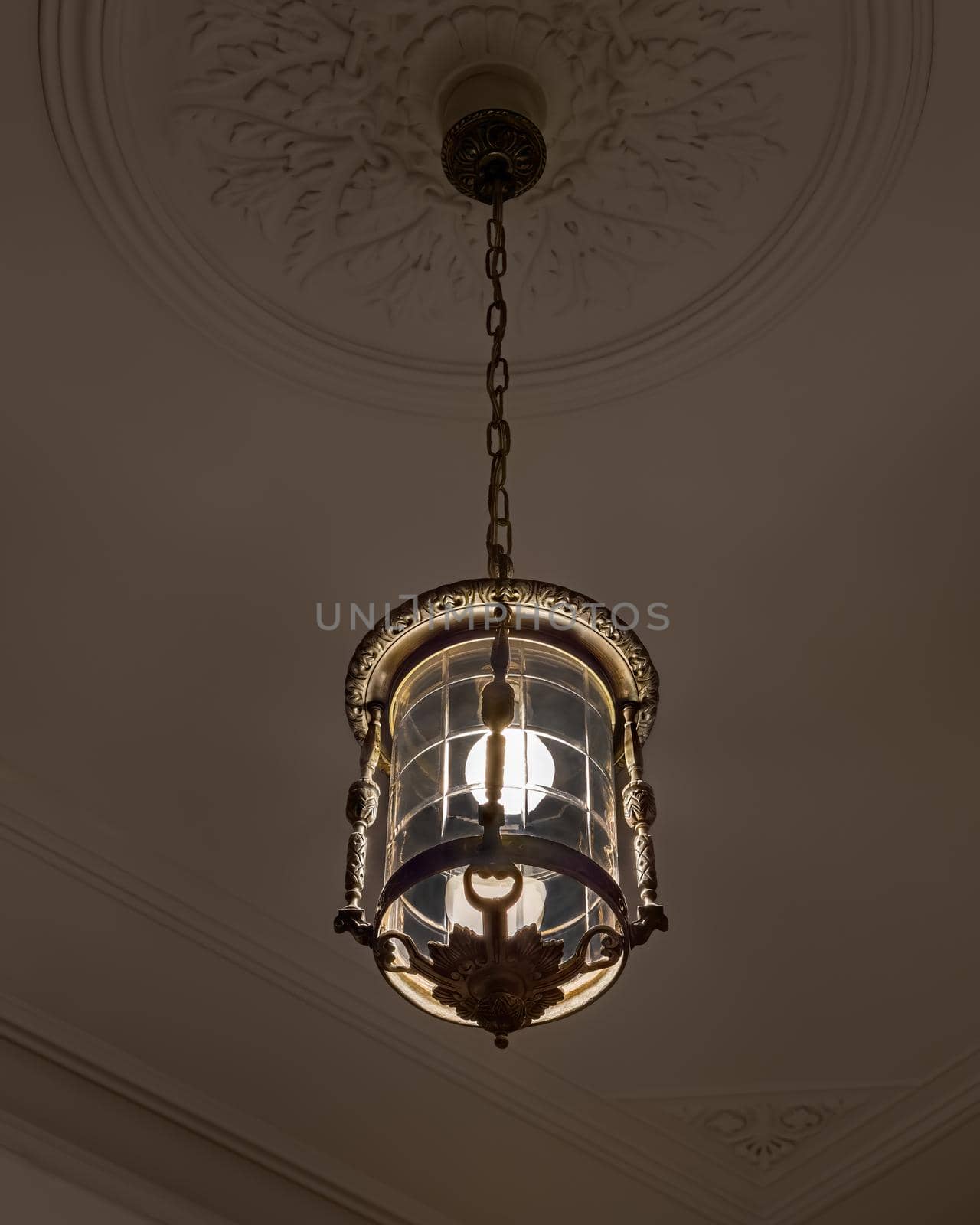 Vintage chandelier in the interior of dark room with with light on by apavlin