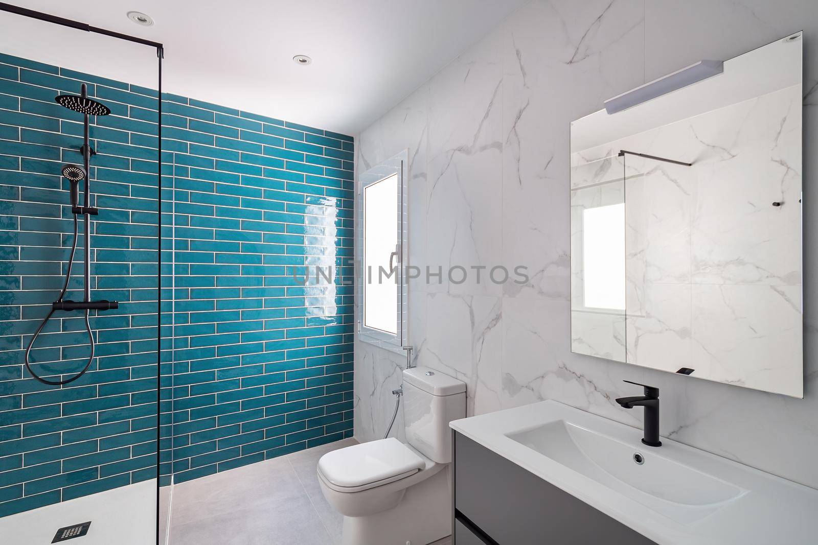 Decorated with dark aquamarine and white colors. Modern tiled bathroom with shower zone, new sink and toilet. by apavlin