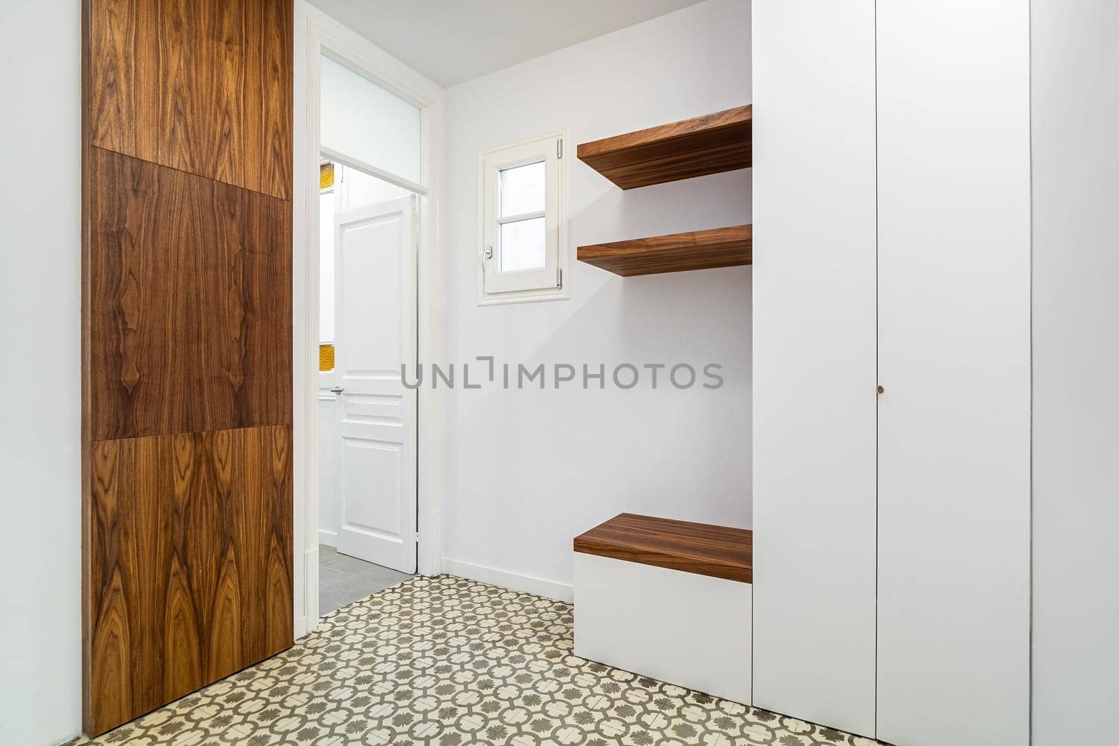 Modern home interior with white walls and cabinets. Hallway with wooden finishing