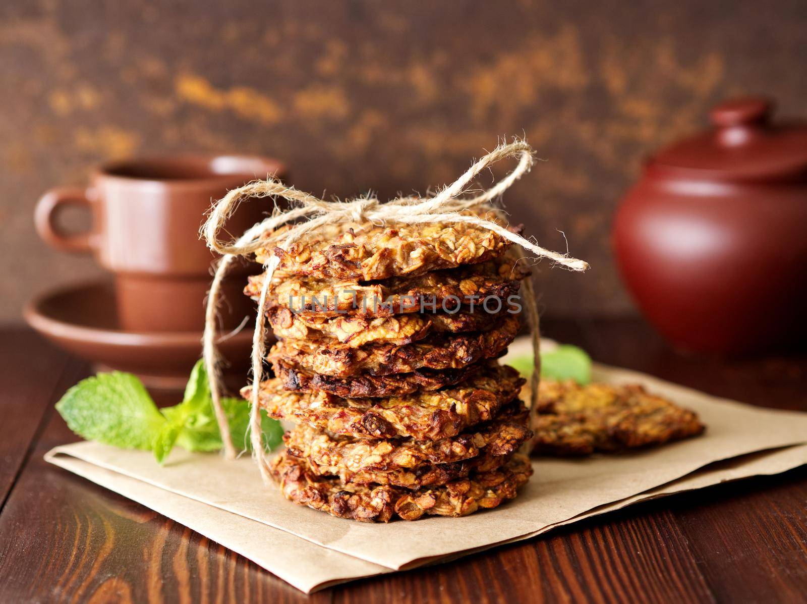 Homemade oatmeal cookies with banana, oats, nuts, eggs and flour free on brown dark wooden by NataBene